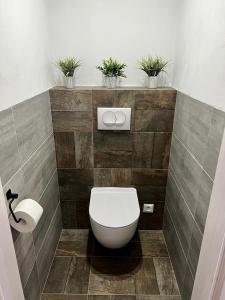 a bathroom with a toilet and plants on the wall at Urban ZION apartment in Liptovský Mikuláš