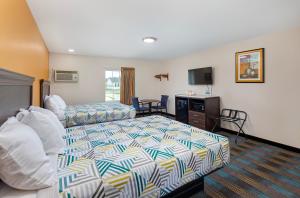 um quarto de hotel com uma cama e um sofá em Cardinal Motel Bowling Green em Bowling Green