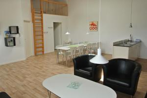 un soggiorno con sedie e tavolo e una cucina di Fitting Landsbyferie Apartments a Vorbasse