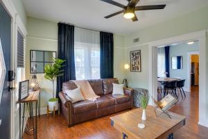 a living room with a brown leather couch and a table at Long Beach Vacation Rental Near Downtown and Beaches in Long Beach
