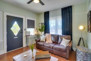a living room with a brown leather couch and a table at Long Beach Vacation Rental Near Downtown and Beaches in Long Beach