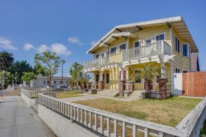 a yellow house with a white fence in front of it at Long Beach Vacation Rental Near Downtown and Beaches in Long Beach