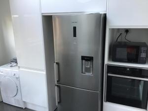 a stainless steel refrigerator in a kitchen with a microwave at Stay near Southmead Hospital and Airbus in Bristol