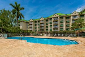 um grande edifício de apartamentos com uma piscina em frente em Sunrise Suites Barbados Suite #204 em Key West