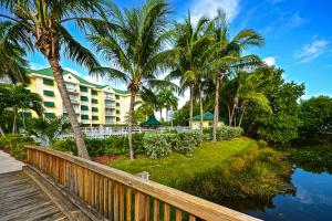 un complejo con palmeras junto a un cuerpo de agua en Sunrise Suites Barbados Suite #204, en Key West