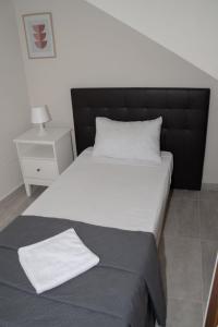 a large bed with a black headboard in a bedroom at Graziosa Penthouse in Il-Ħamrija