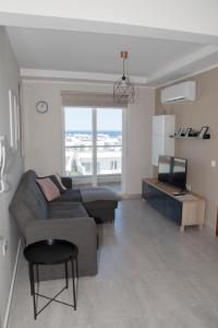 sala de estar con sofá y TV en Graziosa Penthouse en Il-Ħamrija