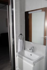 y baño con lavabo blanco y espejo. en Graziosa Penthouse en Il-Ħamrija