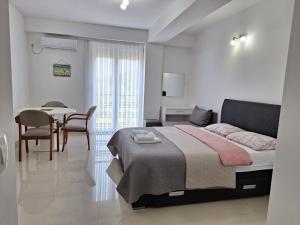 a bedroom with a bed and a table and chairs at Apartments Lakeside Elesec in Ohrid