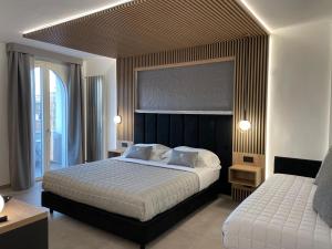 ein Schlafzimmer mit einem großen Bett und einem großen Fenster in der Unterkunft Taormina Rooms centro storico in Taormina