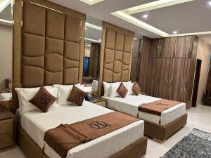 a hotel room with two beds in a room at The Signature Hotel in Islamabad +16 photos