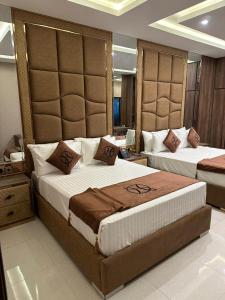 um quarto com 2 camas e uma grande cabeceira em The Signature Hotel em Islamabad
