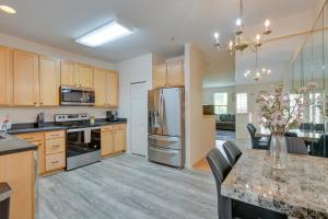 a kitchen with wooden cabinets and a table with a vase of flowers at Owings Mills Townhouse 8 Mi to Liberty Reservoir! in Owings Mills