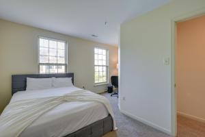 ein Schlafzimmer mit einem großen Bett und zwei Fenstern in der Unterkunft Owings Mills Townhouse 8 Mi to Liberty Reservoir! in Owings Mills