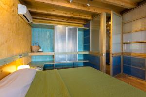 a bedroom with a bed with blue walls and a window at Eleni's Serenity - Discovering Sapphire Harmonies in Ravdhoúkha +35 photos