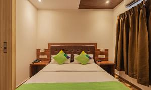 um quarto com uma cama grande e almofadas verdes em Treebo Trend Seven Olives em Mumbai