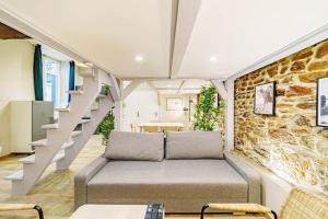 a living room with a couch and a stone wall at Le loft Montesquieu spacieux 6 pers Saxe Gambetta in Lyon