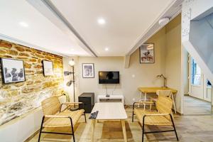 a living room with a table and chairs and a tv at Le loft Montesquieu spacieux 6 pers Saxe Gambetta in Lyon