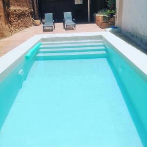 una piscina azul con 2 sillas en el fondo en CASA MOYA-LA ENCARNACIÓN, en Caravaca de la Cruz