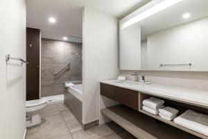 un bagno con lavandino, water e specchio di Four Points by Sheraton Lévis Convention Centre a Lévis