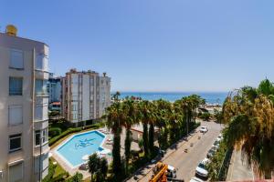 a view of a street with palm trees and a building at Sunny Apartment with Fabulous Sea View in Alanya