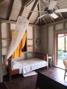a bedroom with a bed with a mosquito net at Rotten Hill Retreat Cottages in English Harbour Town
