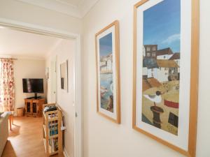 ein Flur mit zwei gerahmten Gemälden an der Wand in der Unterkunft Tre Pol Pen in Falmouth