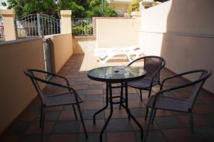 a glass table and chairs on a balcony with a table and two chairs at Apartamentos Turísticos Fercomar in Nerja
