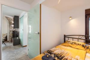 une chambre avec un lit et une paroi vitrée dans l'établissement Apartman Stefani, à Krk