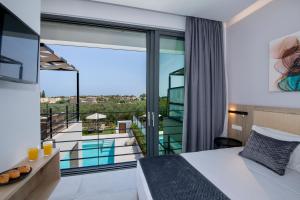 a hotel room with a bed and a balcony at Cretan Queen Residences in Aghii Apostoli