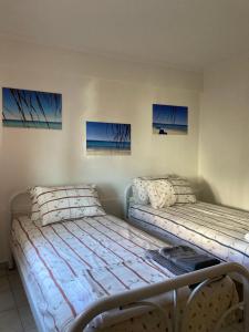two beds in a room with paintings on the wall at Cozy Cottage at Flogita in Flogita
