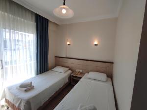 a hotel room with two beds and a window at AYHAN OTEL in Çeşme