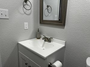 a bathroom with a white sink and a mirror at Modernized Stay in Eagle Pass