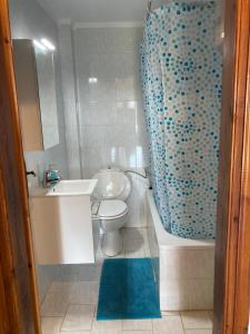La salle de bains est pourvue d'un lavabo, de toilettes et d'une baignoire. dans l'établissement Cozy Cottage at Flogita, à Flogita