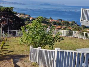 een wit hek met uitzicht op de oceaan bij Apartamento mirador a las Islas Cíes in Cangas de Morrazo