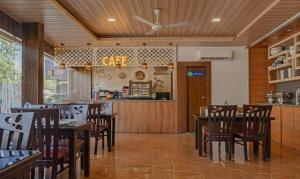 restauracja z drewnianymi stołami i krzesłami oraz blatem w obiekcie Treebo Trend Seven Olives w Bombaju