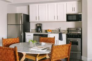 uma cozinha com armários brancos e uma mesa com cadeiras em Sonder Georgetown C&O em Washington