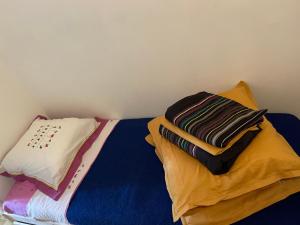 Una cama con sábanas y almohadas coloridas. en Studio Cabine Clim Wifi Parking Draps - 1 étoile - self check-in possible en La Grande-Motte
