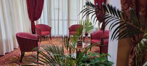 a room with red chairs and a table and plants at HOTEL PARADISO in Altedo