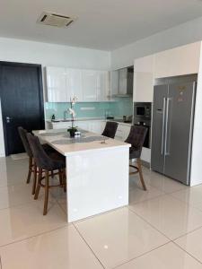 a kitchen with a table with chairs and a refrigerator at Tropicana Grande Luxurious Stay in Kota Damansara