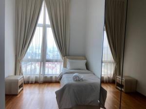 a bedroom with a bed in front of a large window at Tropicana Grande Luxurious Stay in Kota Damansara