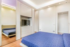 a bedroom with a blue bed and a tv at Luxury apartment front of Cavalieri Hilton Hotel in Rome