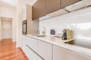 a kitchen with white cabinets and a sink at Luxury apartment front of Cavalieri Hilton Hotel in Rome