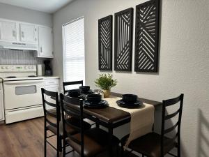 a kitchen with a table and chairs and a kitchen with white appliances at Modernized Stay in Eagle Pass