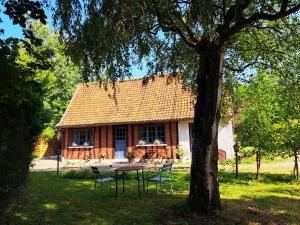 una mesa y sillas frente a una casa en Le Bois d'Albran en La Calotterie