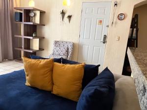 a blue couch with yellow pillows in a living room at CENTRO, CERCA ToDo in Cancún