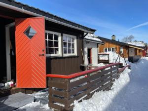 a house with a red door in the snow at Fin fritidsbolig nært alpinanlegg og skiløyper in Oppdal