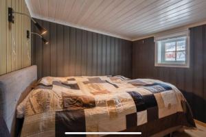 a bedroom with a bed in a room with a window at Fin fritidsbolig nært alpinanlegg og skiløyper in Oppdal