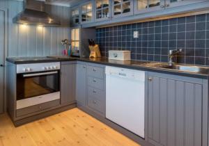 a kitchen with a sink and a stove top oven at Fin fritidsbolig nært alpinanlegg og skiløyper in Oppdal