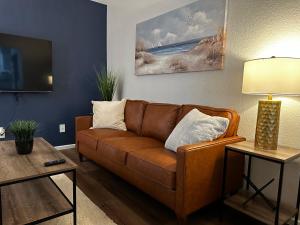 a living room with a brown couch and a table at Modernized Stay in Eagle Pass